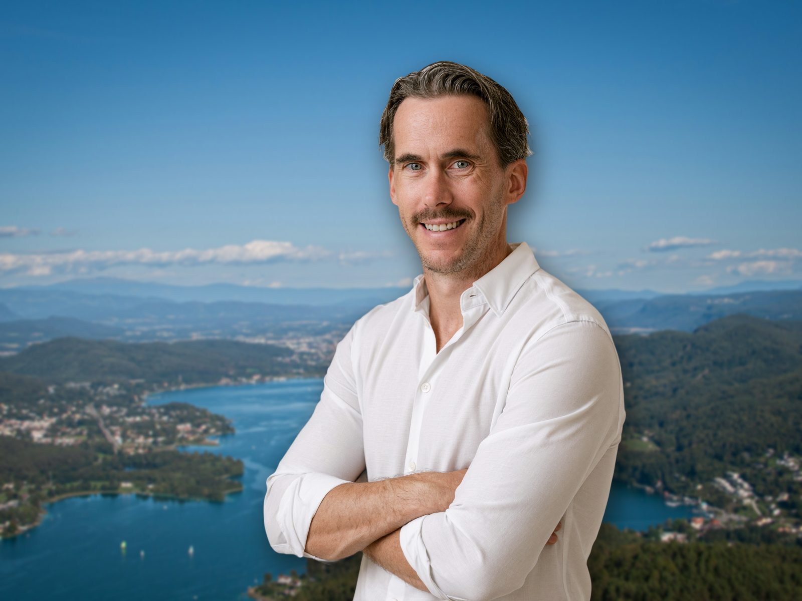Jürgen Galo, Immobilienmakler, vor dem Wörthersee mit Blick auf Klagenfurt