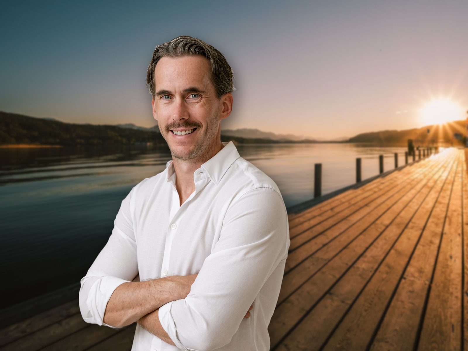 Jürgen Galo, Immobilienmakler, auf einem Steg am Wörthersee im Abendlicht